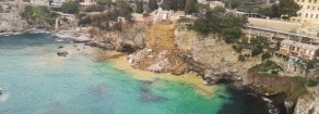 Un costone a picco sul mare che frana e centinaia di bare che galleggiano in acqua